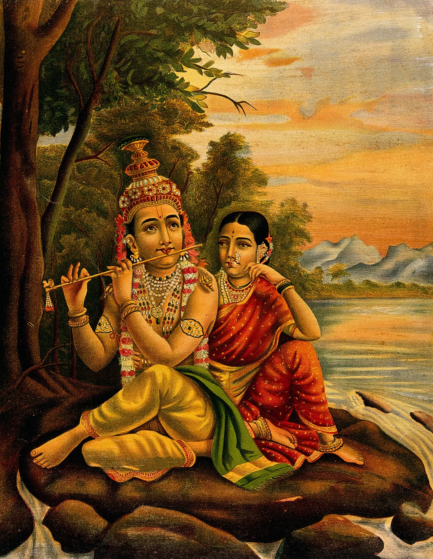 नदी किनारे पेड़ों की छाँव में मुरली बजाते हुए श्रीकृष्ण, और पास बैठकर मुरली सुनतीं राधा जी
